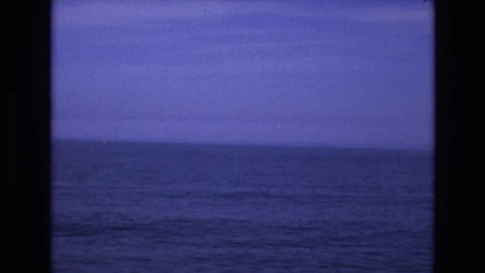 1973 8mm Salt Lake City-area home-movie frame showing open blue water and a distant horizon, with film gate edges visible.