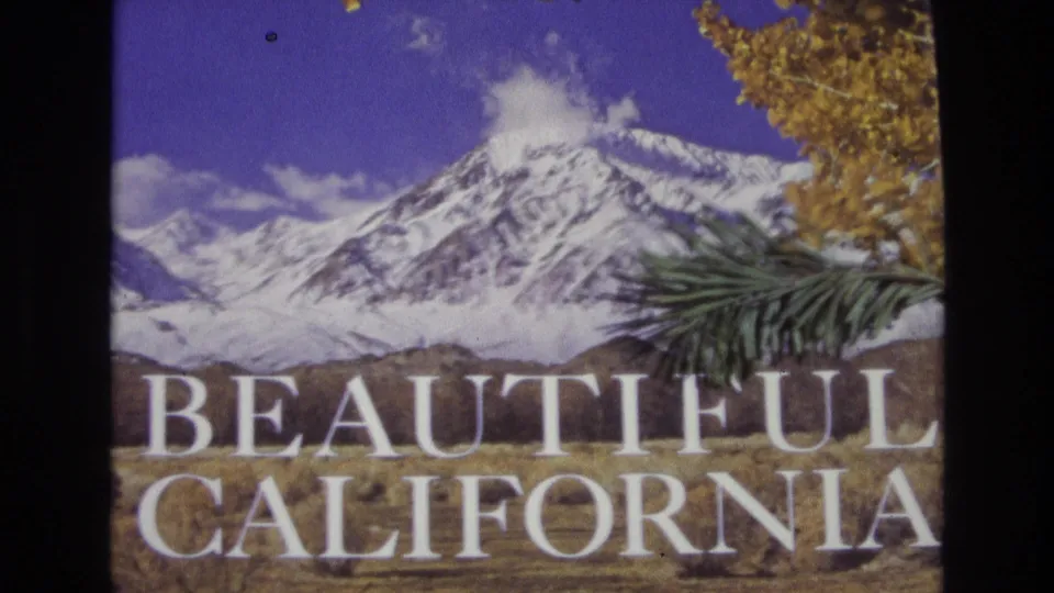 1973 8mm-style travel-title frame showing Beautiful California text across a mountain landscape with snow, blue sky, golden leaves, and a pine branch in the foreground.