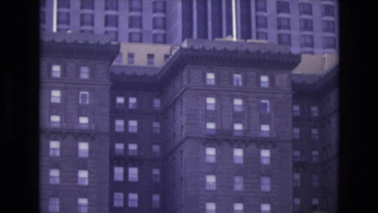 Tall hotel building facade with rows of windows and dark film border.