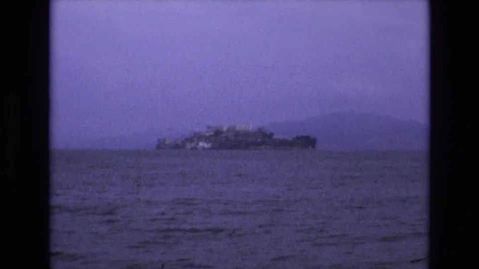 Distant view across San Francisco Bay toward Alcatraz Island, seen through soft 8mm focus and a blue-purple film cast.