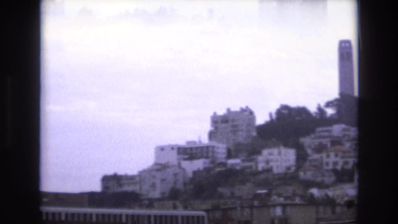 1973 San Francisco view toward Coit Tower, with hillside residences and trees seen through soft 8mm home-movie framing.