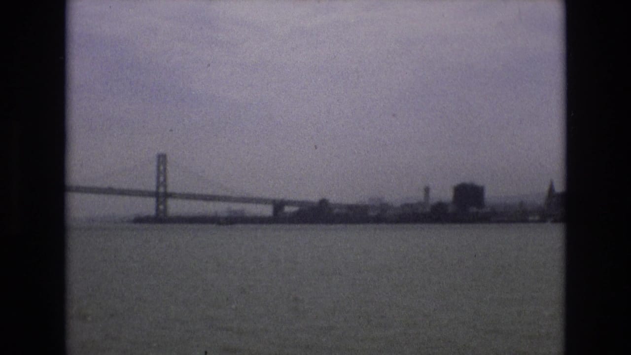 Bay Bridge and distant San Francisco waterfront across hazy bay water.