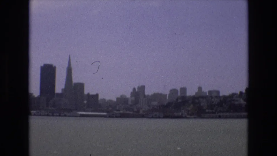 A softer 1973 San Francisco bay view shows the Transamerica Pyramid at left, distant waterfront buildings, and open water in the foreground.