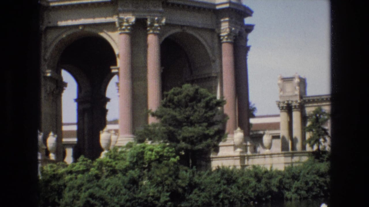 1973 8mm San Francisco footage shows the Palace of Fine Arts rotunda with tall columns, archways, shrubs, and the reflecting pool in the foreground.