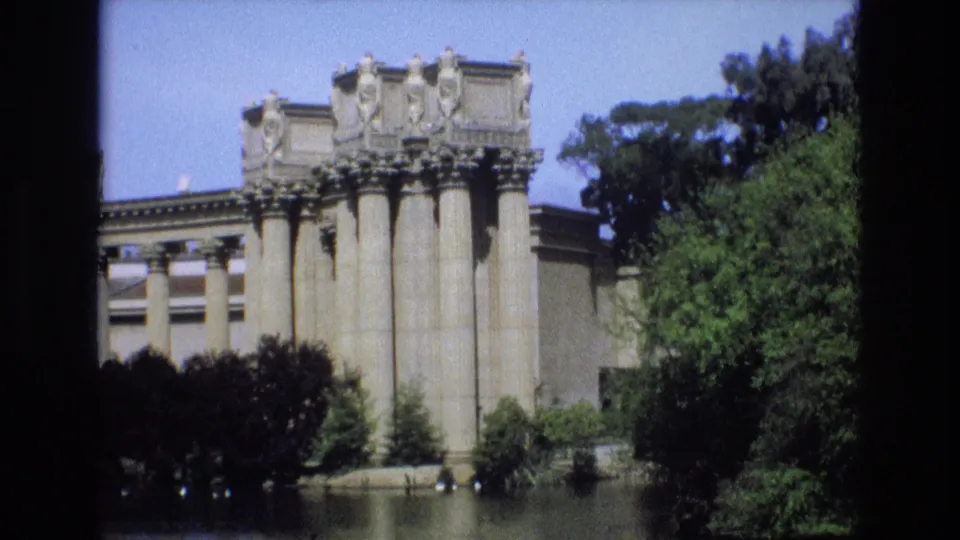 1973 San Francisco frame showing a columned classical structure beside calm water, with surrounding trees and visible 8mm scan borders.