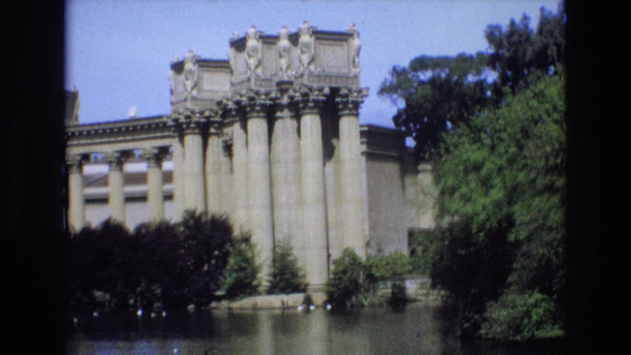 1973 San Francisco 8mm frame showing a columned classical-style structure at the edge of a lake, partly obscured by trees and dark contact-sheet borders.