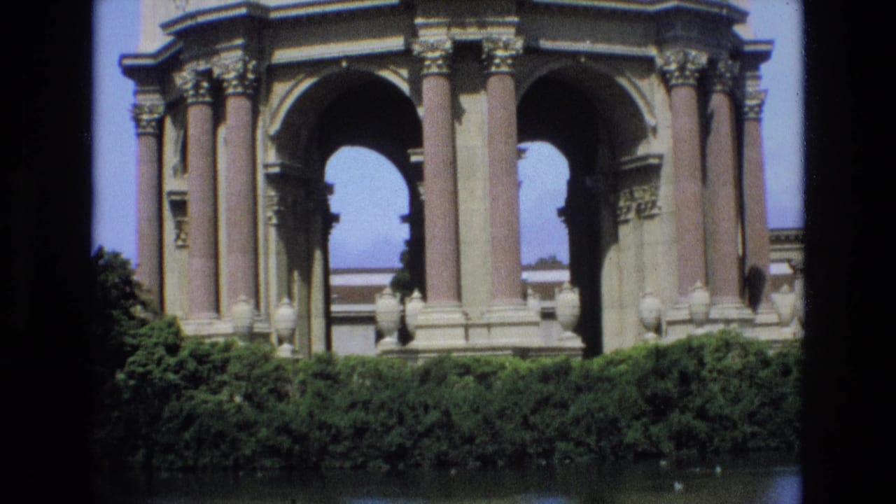 1973 San Francisco frame with the Palace of Fine Arts colonnade and arches rising behind dense hedges beside the lagoon.
