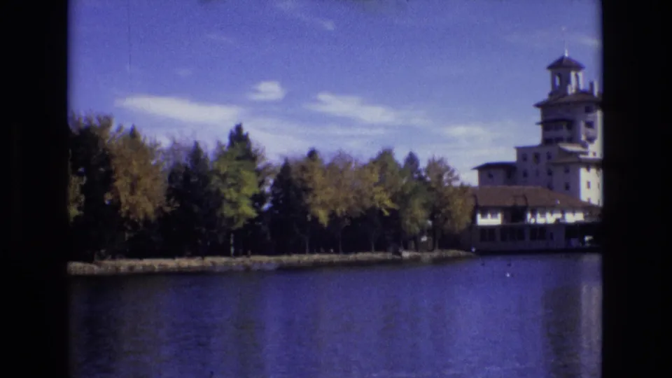 The final frame shifts the Broadmoor Hotel toward the right edge, emphasizing the lake, autumn trees, shoreline, and bright Colorado sky.