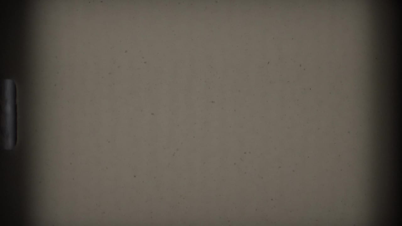 Mostly blank film area with a partial view of a Denver lawn and building at the right edge.