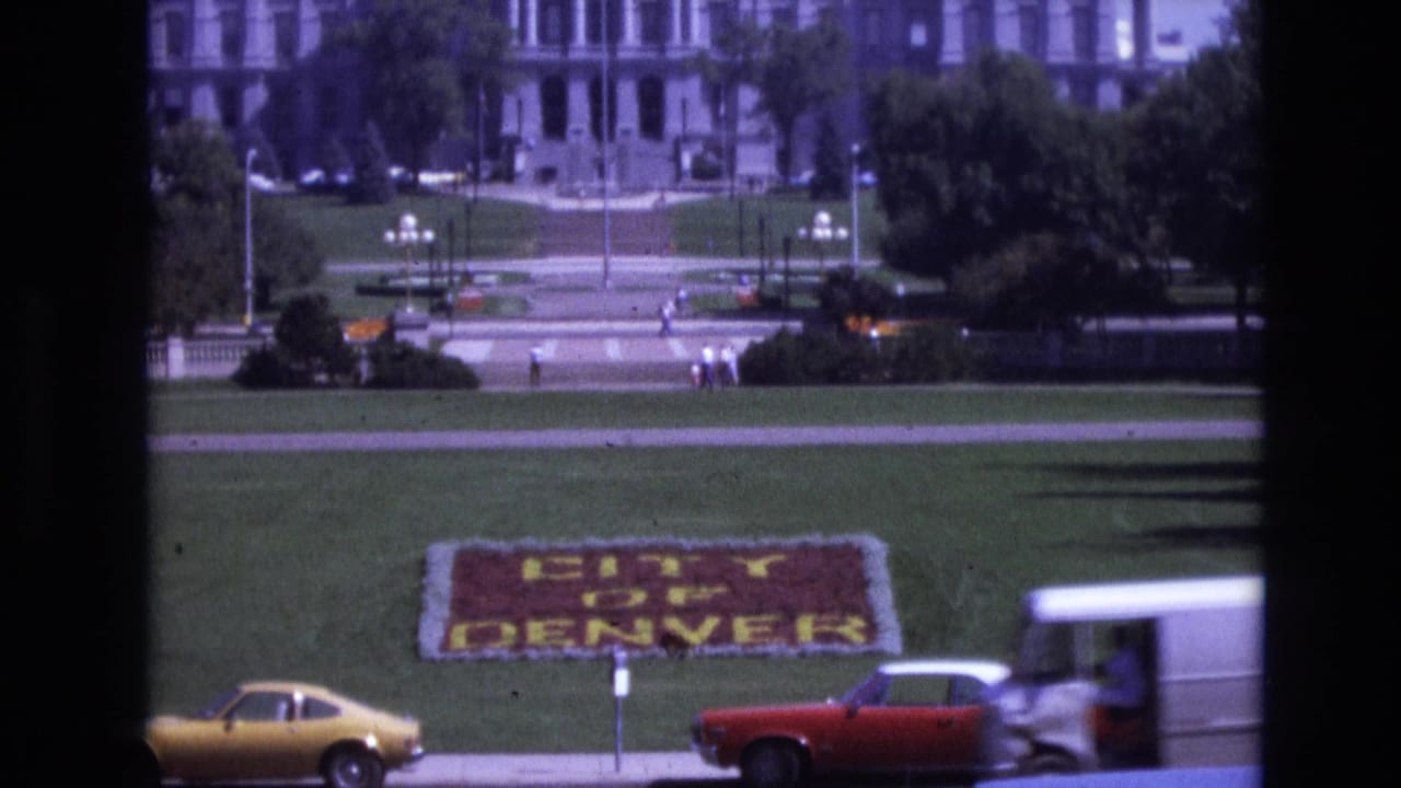 City of Denver floral sign on a lawn with cars passing in front.