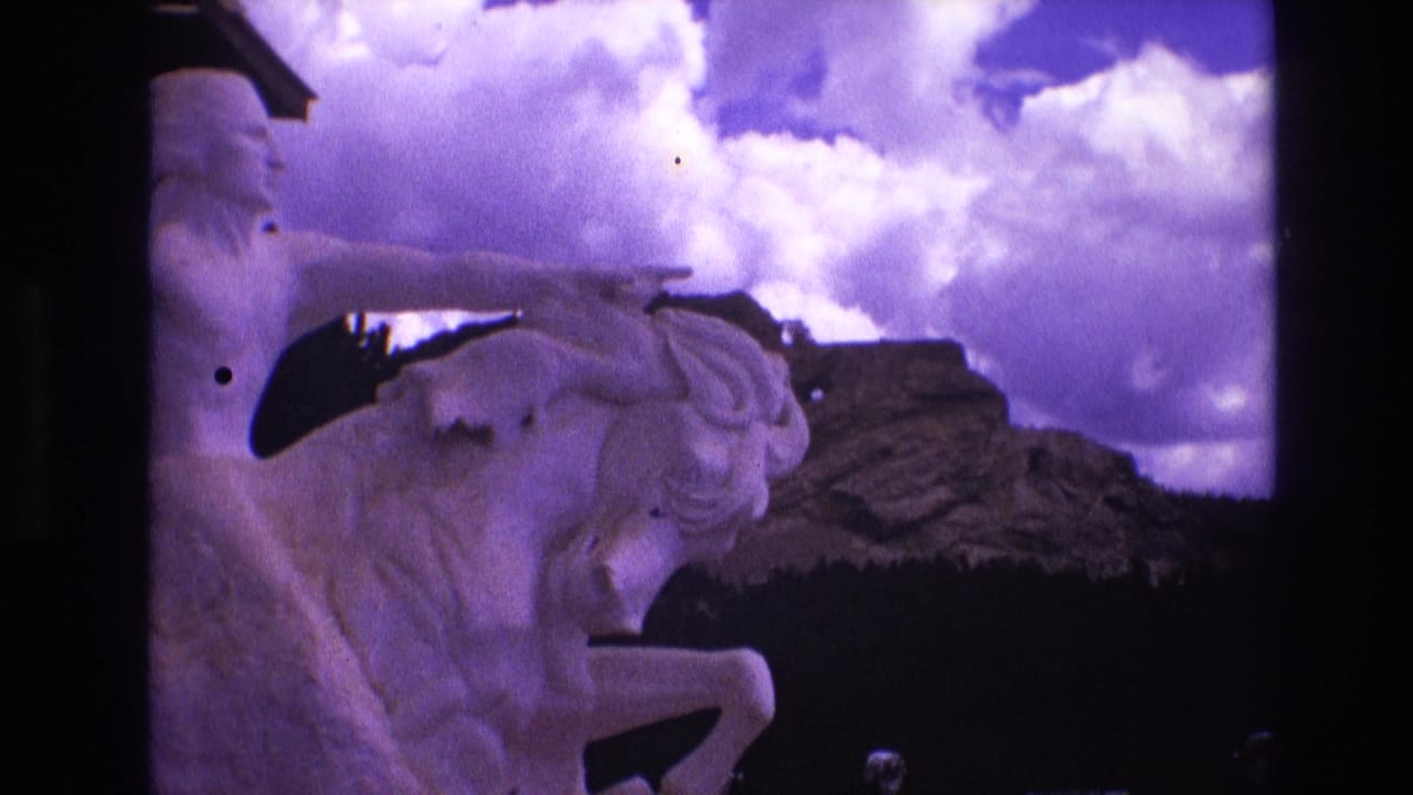 Horse-and-rider statue partly framed by dark film edges and clouds.