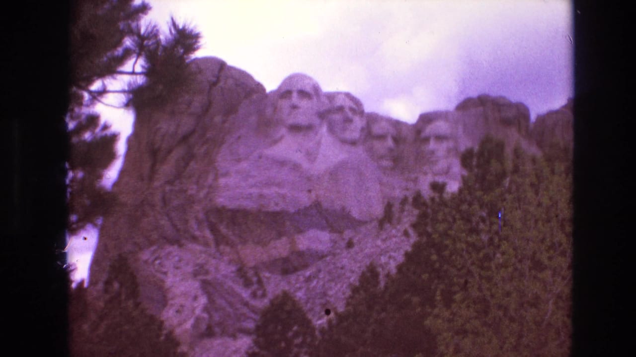 Closer view of Mount Rushmore with trees at the lower right.