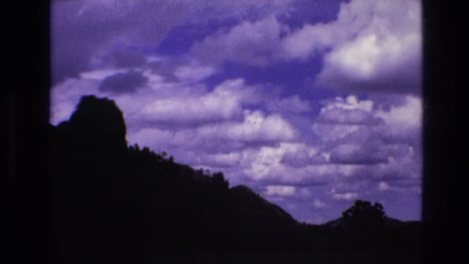 The final frame is dominated by a blue-purple cloudy sky above a dark South Dakota hillside, with only a faint foreground silhouette remaining near the lower edge.