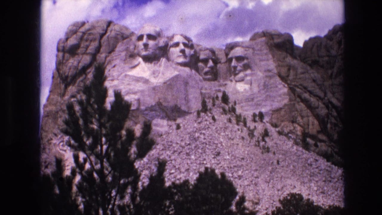 Mount Rushmore sculptures viewed from below with trees in the foreground.