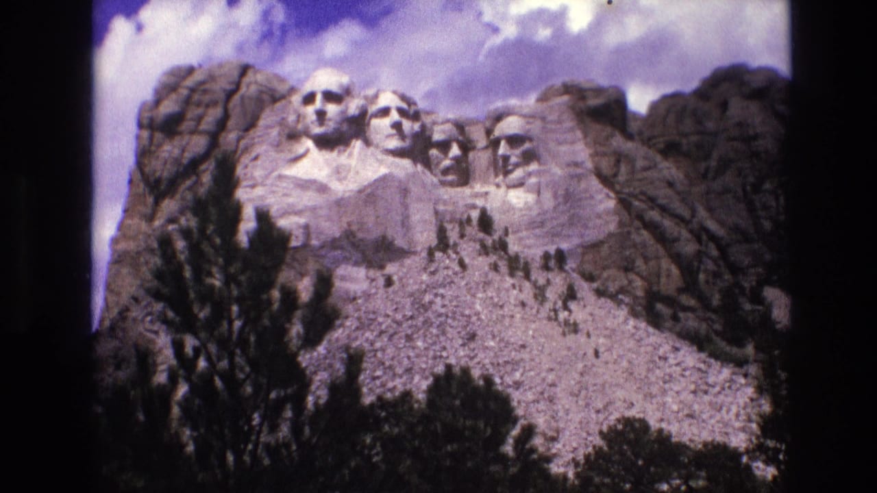 Mount Rushmore carvings centered above trees and rocky slopes.