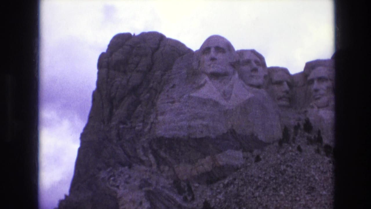 Mount Rushmore presidential heads framed by dark film borders.