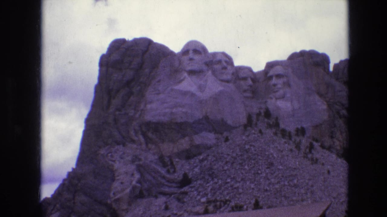 Mount Rushmore presidential carvings remain centered with dark vertical film borders.