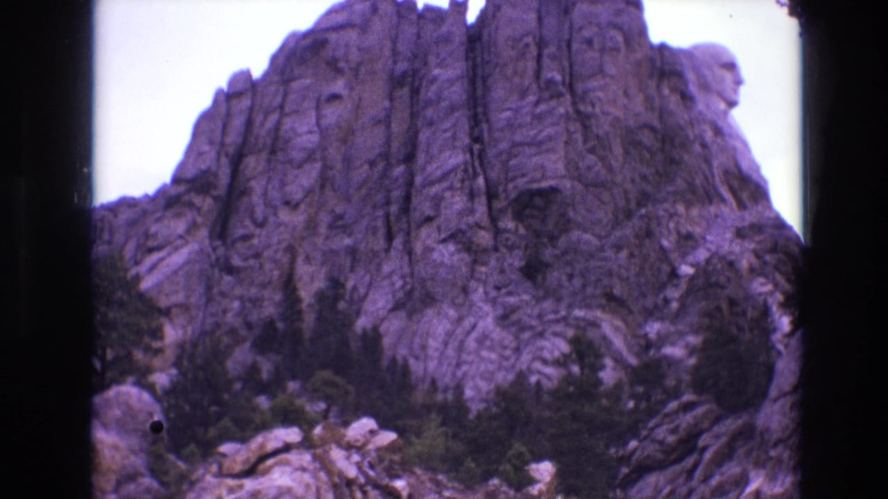 Closer view of Mount Rushmore and surrounding granite cliffs with trees below.