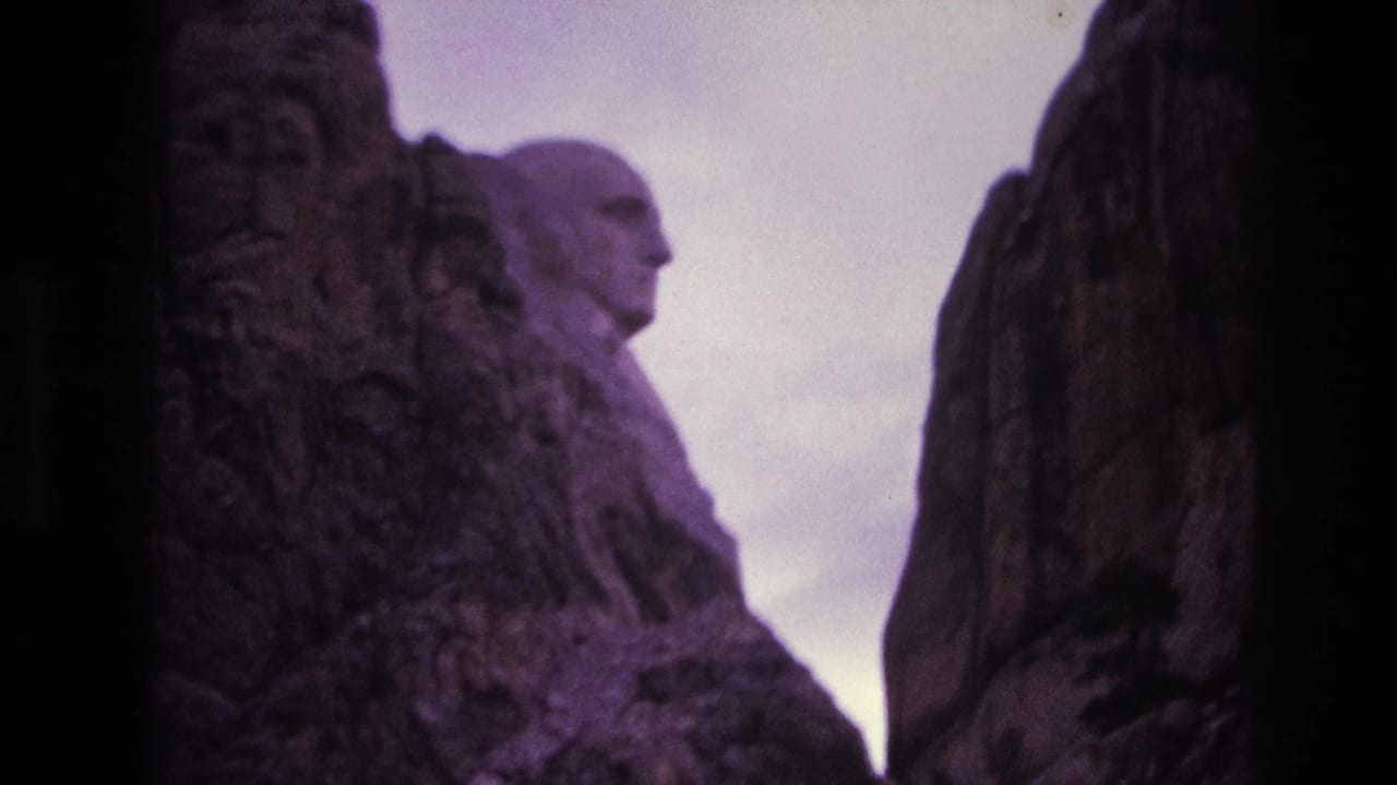 Side view of George Washington's carved face framed by tall granite formations.