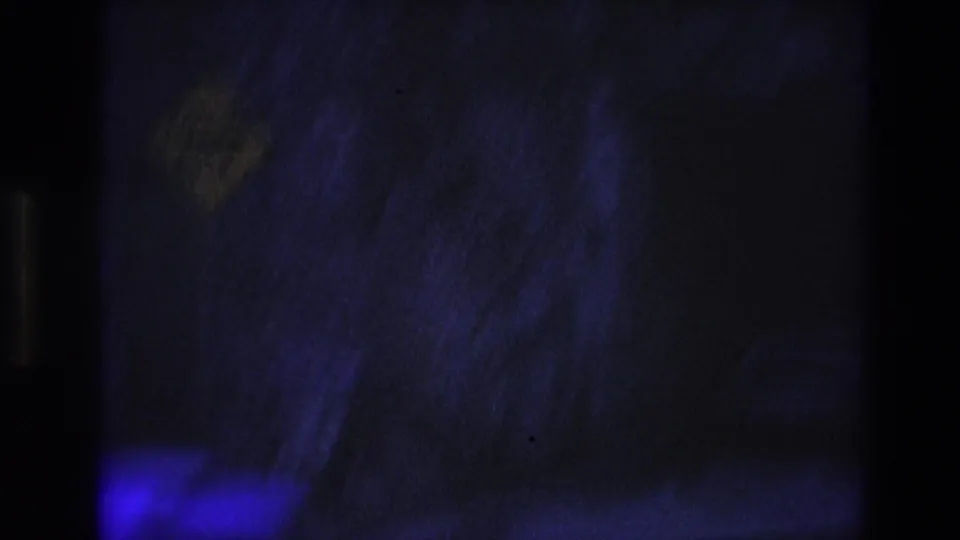 Low-light 1974 South Dakota frame with rough rock surfaces, deep blue-purple color, and a mostly shadowed passageway area.