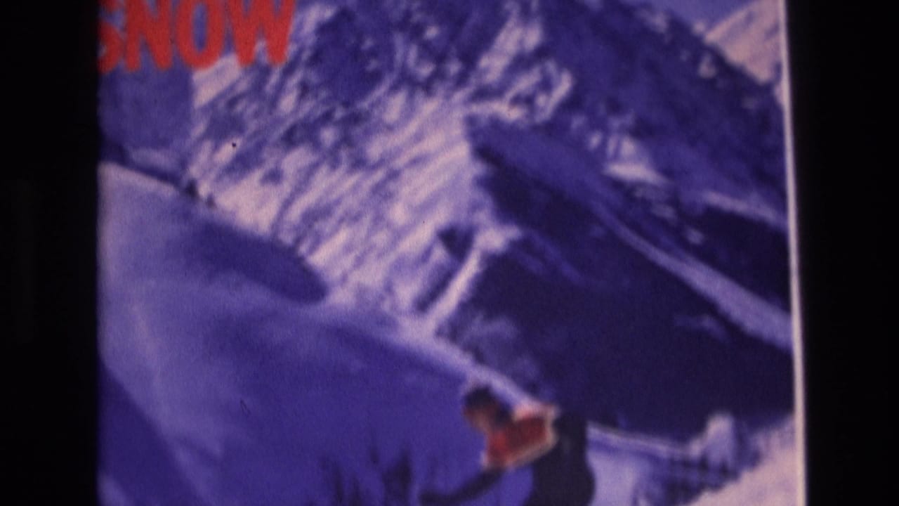 Skier in red and dark clothing descends a snowy slope below a mountain graphic area.