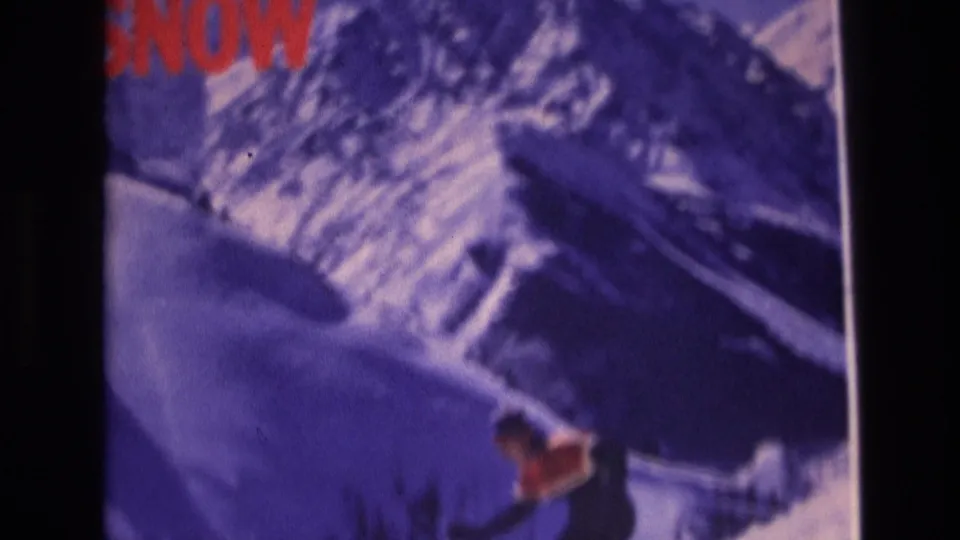 A skier in red and dark clothing moves across a snowy Vail, Colorado slope in the 1974 8mm footage, with the opening graphic still partly visible at the top.