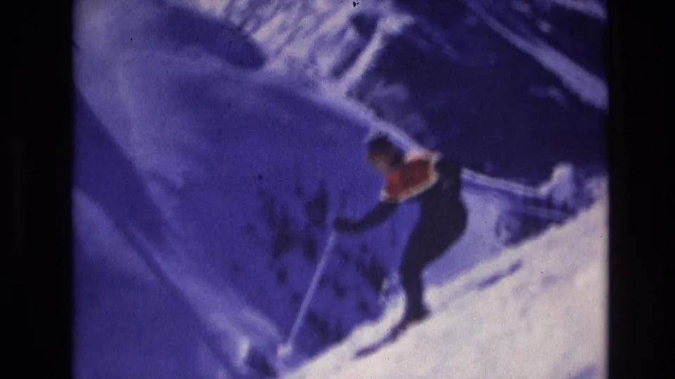 The skier remains in motion on the snowy Vail slope at the end of the 1974 8mm clip, framed with visible grain, soft focus, and a purple color cast.