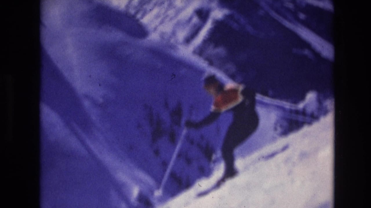 A lone skier continues downhill across a blue-toned snowy slope, with poles extended and the figure partly softened by 8mm motion blur.