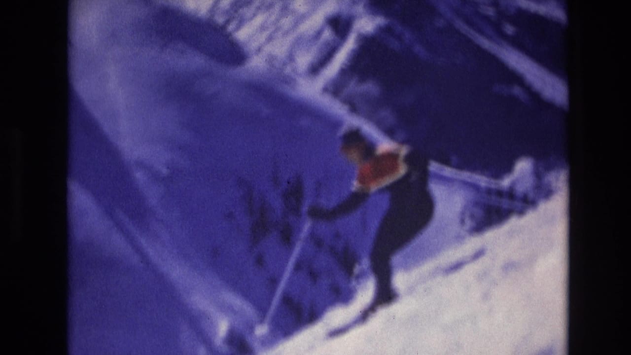 1974 Vail, Colorado 8mm frame showing a skier in dark clothing with a red accent moving downhill on a snowy slope.