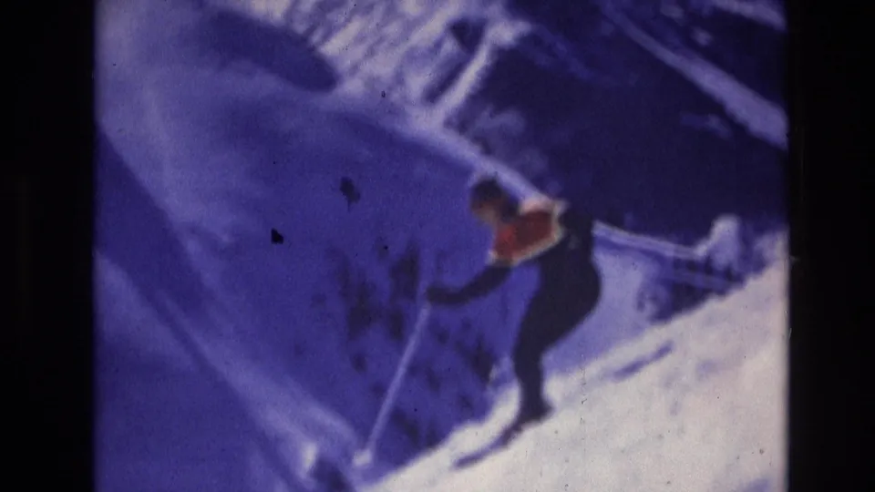 1974 Vail, Colorado 8mm frame with a skier crossing a snow-covered slope, partly softened by grain and purple color shift.