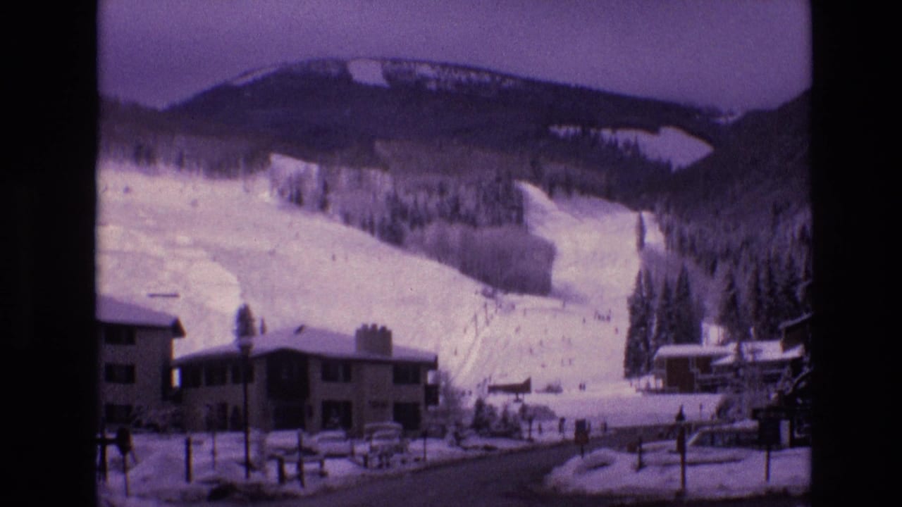 1974 Vail, Colorado home-movie frame showing snow-covered lodge buildings and ski runs at the base of Vail Mountain.