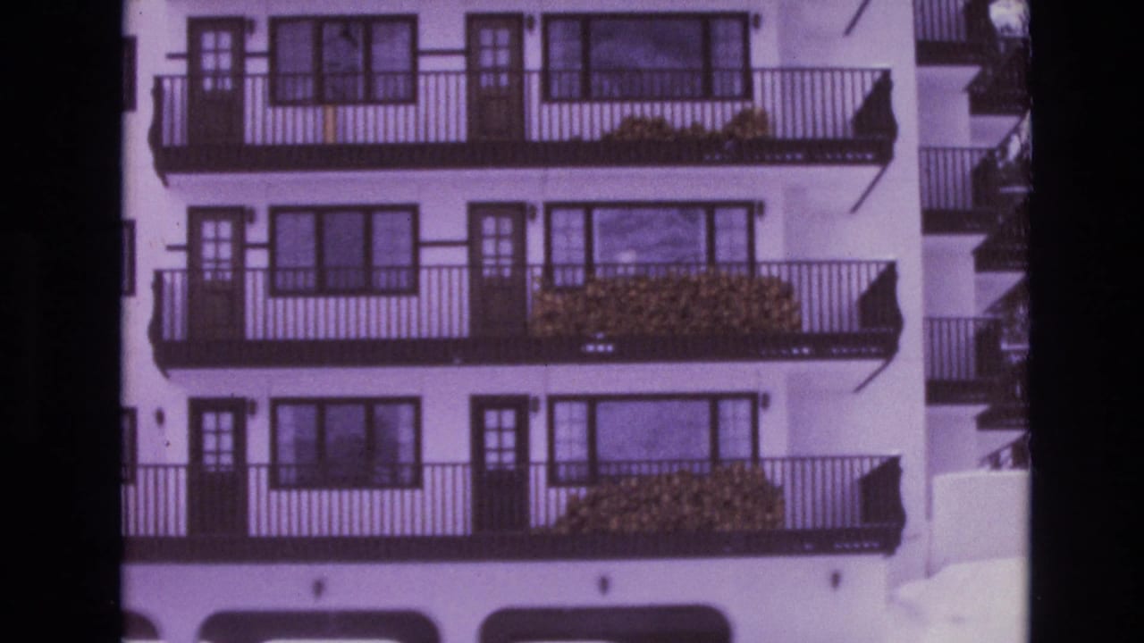 Resort facade with balconies, windows, and snow nearby.