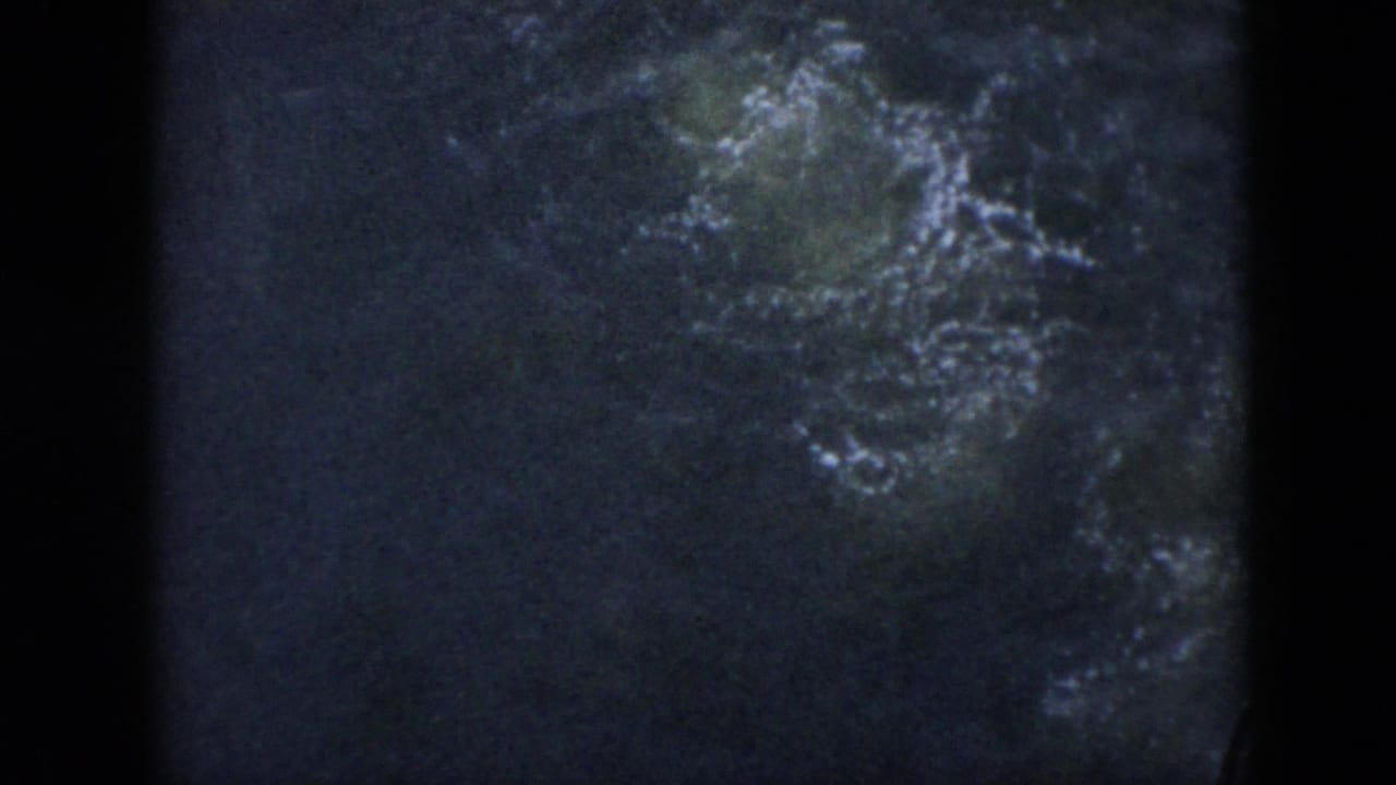 1956 Cuba 8mm frame with disturbed dark water and pale bubbles where the swimmer has gone underwater.