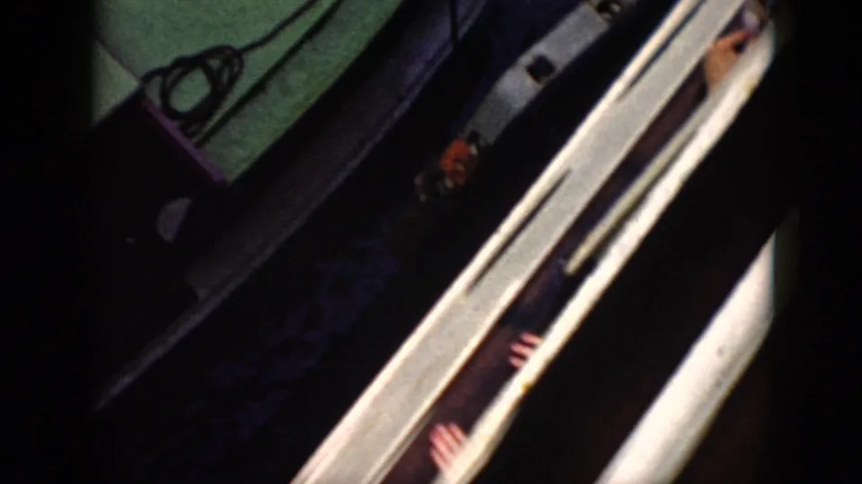 1956 Cuba 8mm view down along a boat edge, with green deck, rope, water, and partial hands near the rail.