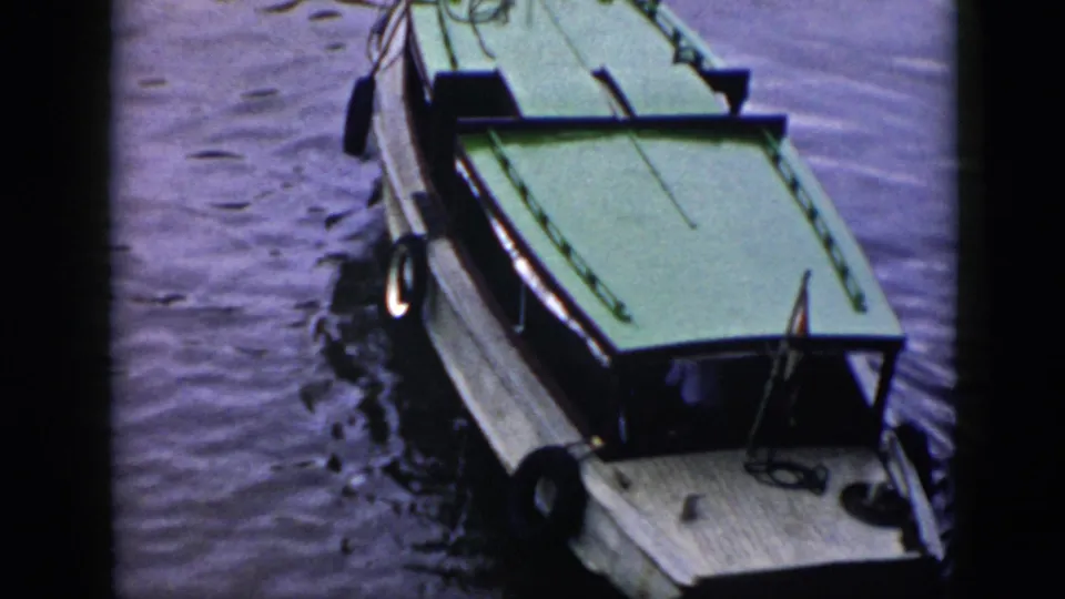 1956 Cuba frame showing the green-roofed white boat moving through rippled water from an overhead viewpoint.