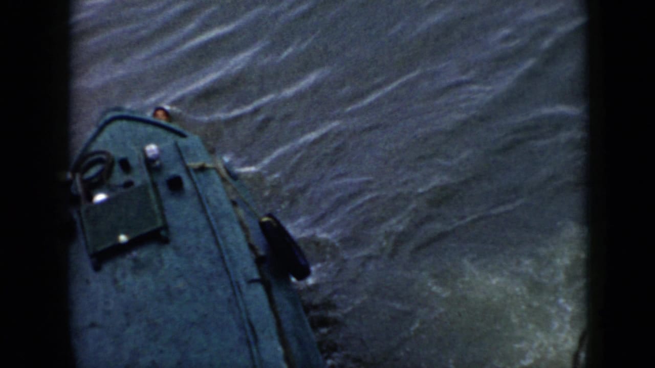 1956 Cuba 8mm frame showing a small green boat on choppy water with a swimmer partly visible beside the bow.