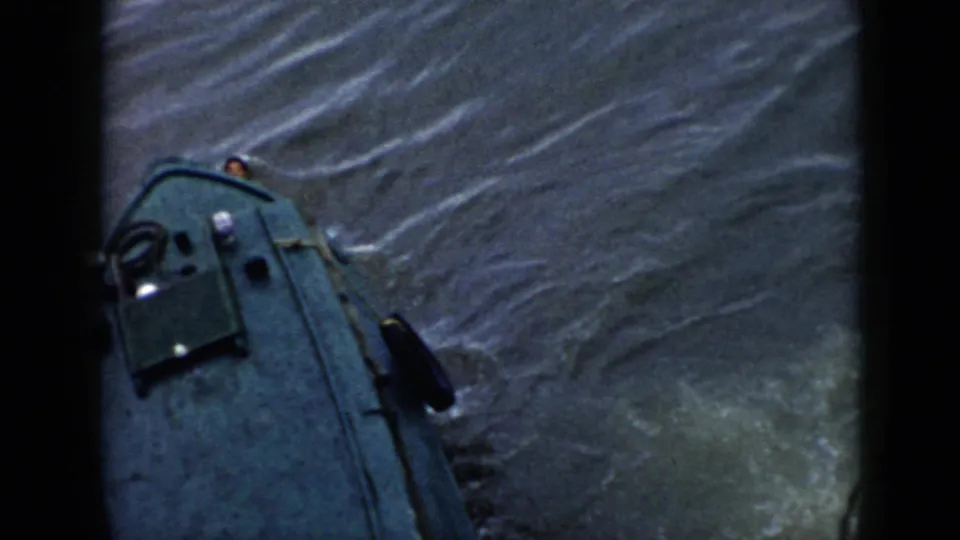 1956 Cuba 8mm frame showing a small green boat on choppy water with a swimmer partly visible beside the bow.
