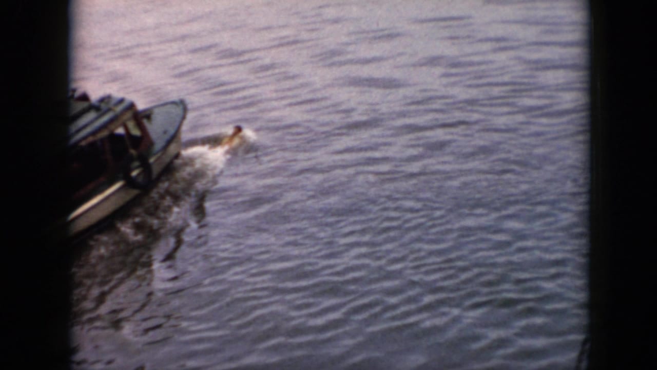 Boat continues across open water with a swimmer near the stern wake.