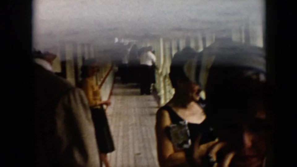 1956 Cuba 8mm frame showing adults on a tiled covered waterfront deck, with soft focus and dark frame edges.
