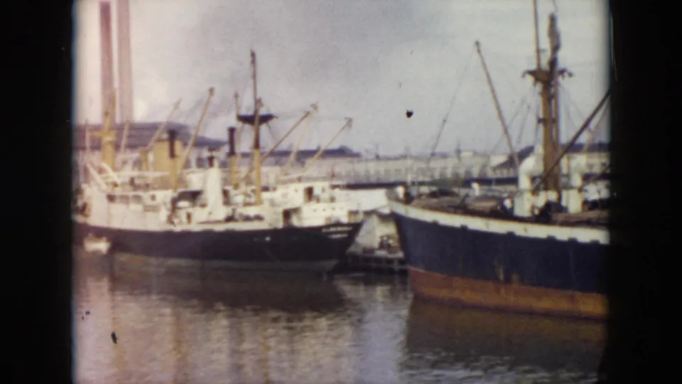 1956 Cuba harbor frame showing docked cargo ships, masts, hulls, and industrial waterfront activity.