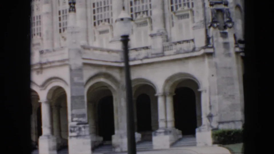 1956 Cuba footage shows the lower level of a historic building with arched porticoes, columns, steps or walkways, and a streetlamp.