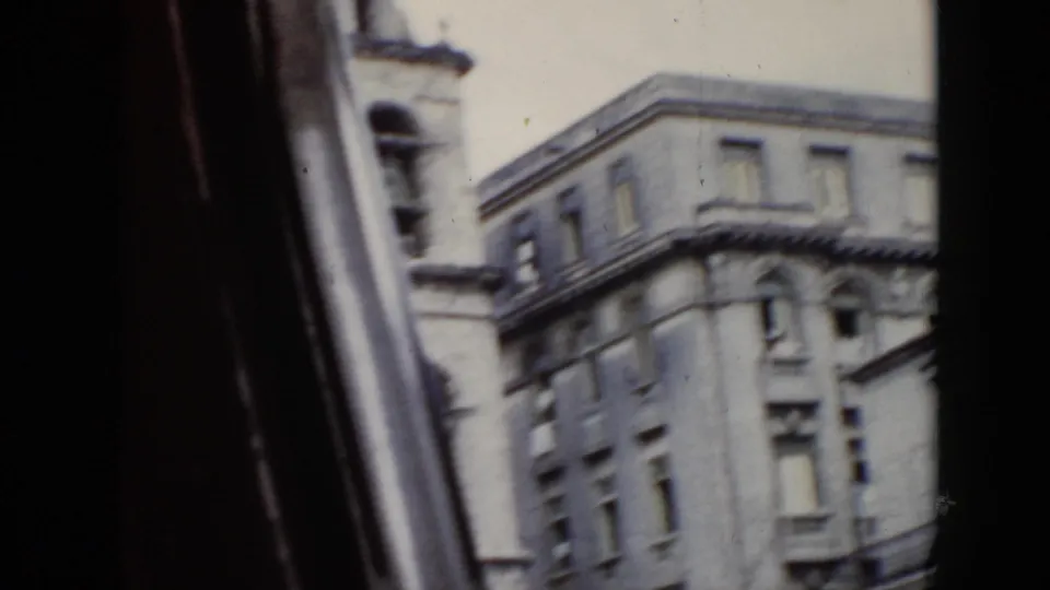 1956 Cuba street footage with motion blur, showing a tall corner building and part of a nearby bell tower.