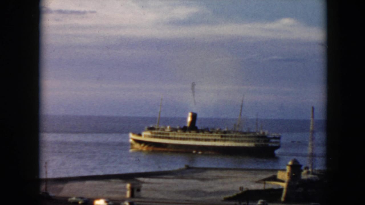 1956 Cuba harbor view of a passenger steamship moving across calm water, seen from an elevated home-movie vantage point.