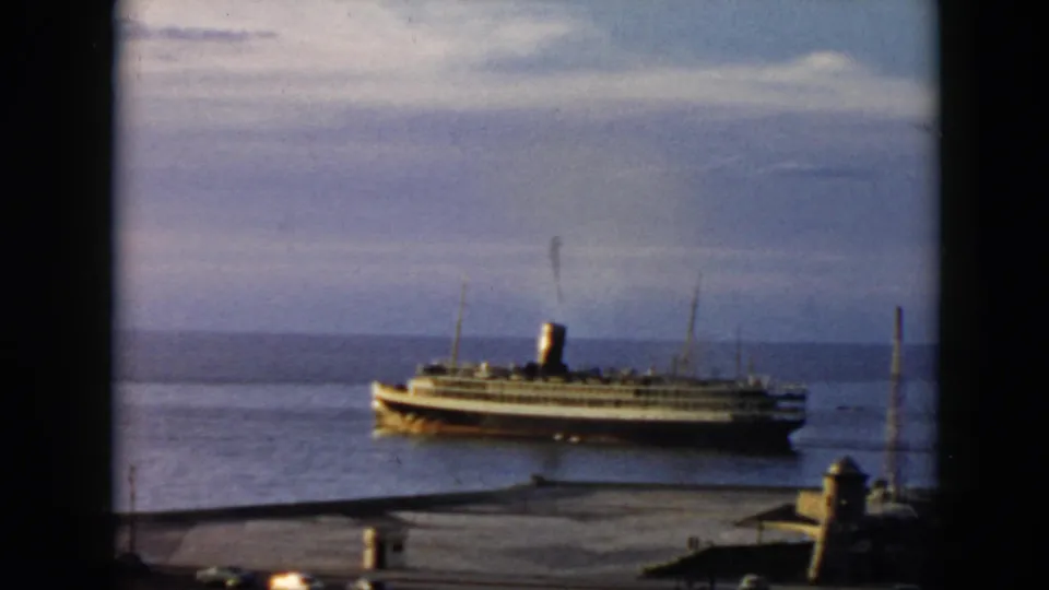 1956 Cuba harbor view of a passenger steamship moving across calm water, seen from an elevated home-movie vantage point.