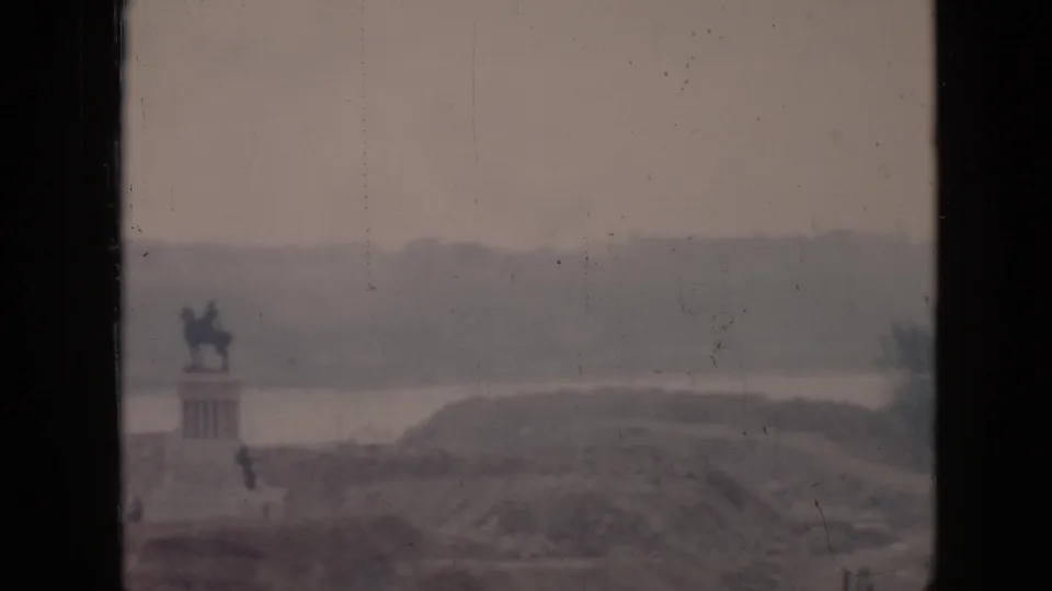 Final 1956 Cuba frame holding the same distant equestrian statue and landscape, with muted color and visible 8mm film scratches.