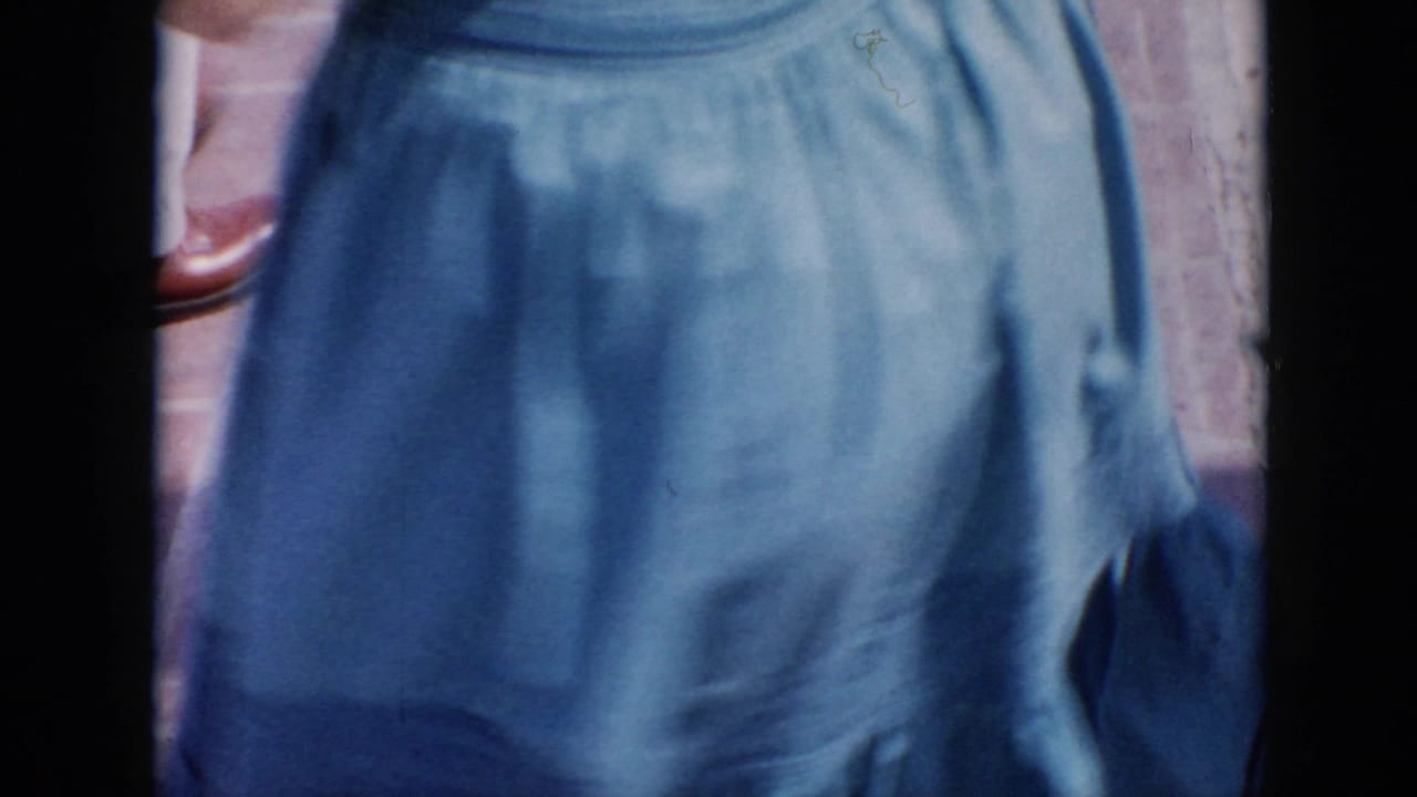 Close cropped view of a blue skirt beside a dark vertical film-frame edge.
