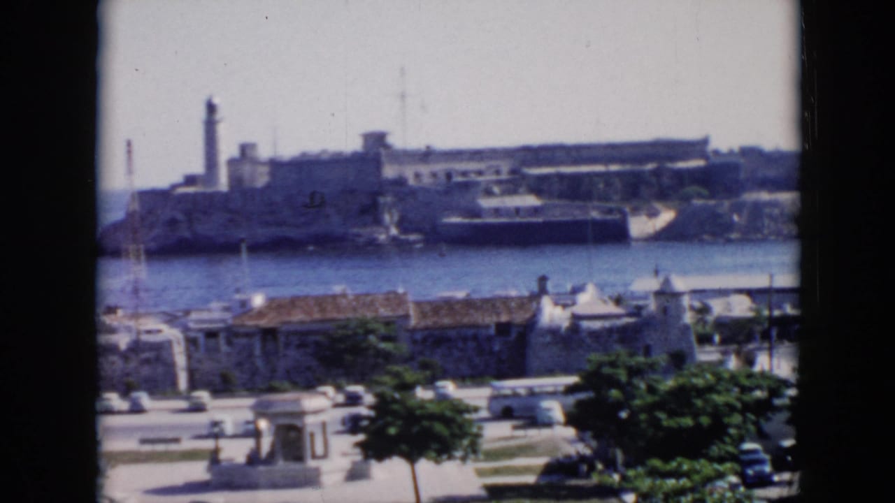 1956 Cuba home-movie view of a large harbor fortress, likely El Morro per clip metadata, seen across water from an elevated waterfront vantage.