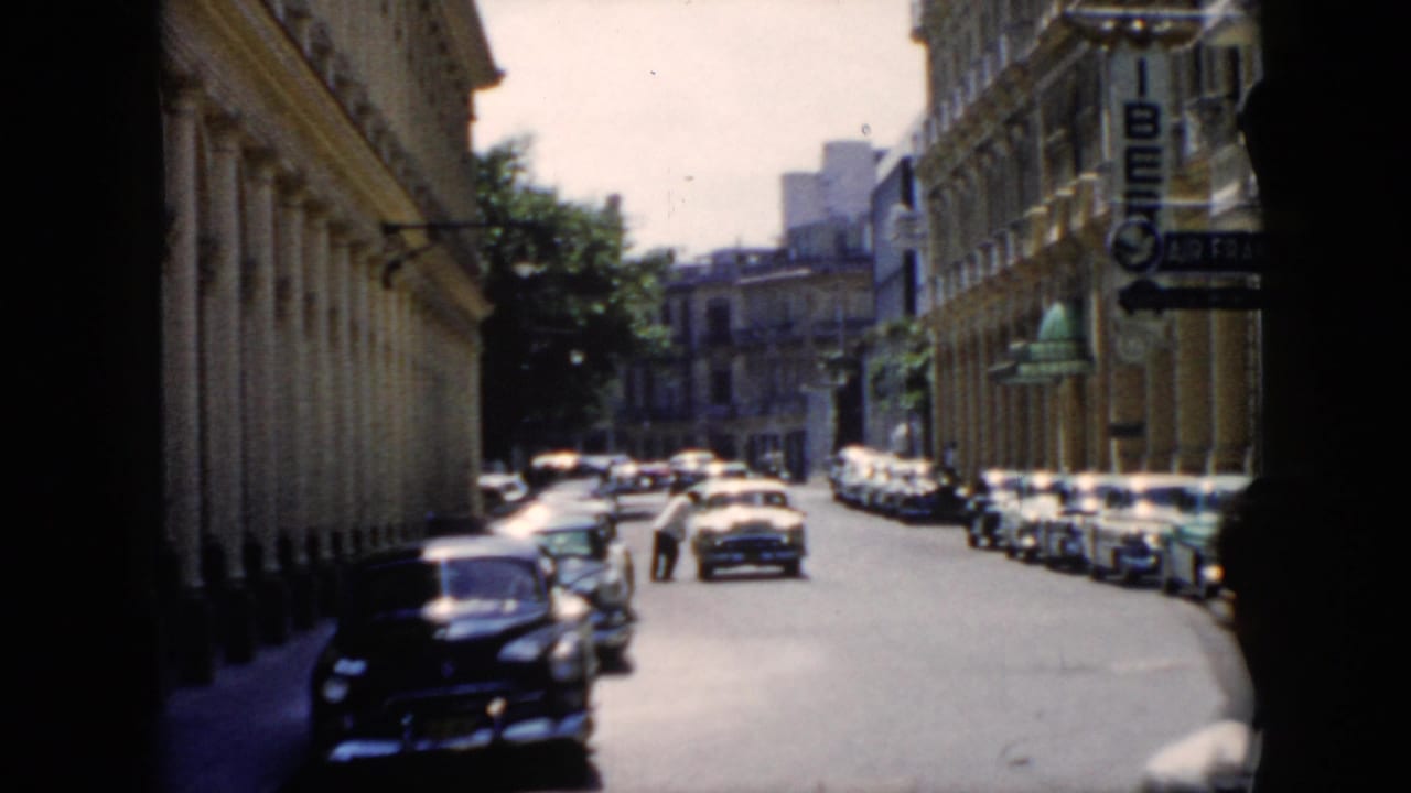 Street scene with rows of parked cars and visible Air France signage on a building.