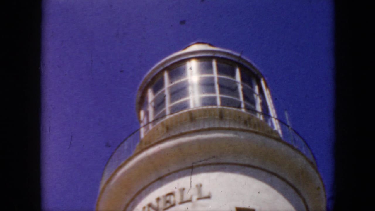 1956 Cuba 8mm frame showing the upper portion of a rounded observation tower or lighthouse-like structure against blue sky.