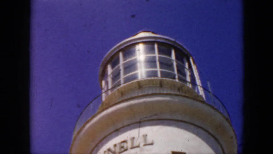 1956 Cuba 8mm frame showing the upper portion of a rounded observation tower or lighthouse-like structure against blue sky.